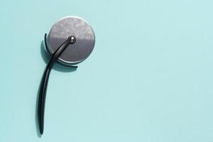 Pizza cutter with a black plastic handle on a blue background photo