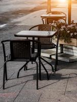 mesa y sillas en una cafetería en la acera. foto