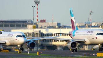 DUSSELDORF, GERMANY JULY 21, 2017 - Three Eurowings airplanes Airbus 320 waiting in line to the start at sunset. Dusseldorf airport video