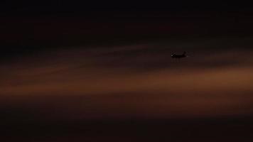 el avión en la aproximación final antes de aterrizar en el fondo del cielo del atardecer video