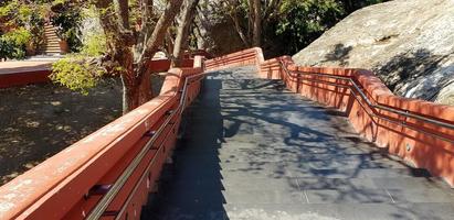 Gray stairway with red handrail for people walk up or down with shady trees and shadows. Exterior design photo