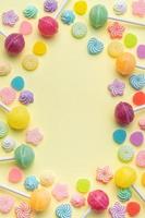 Sweet lollipops and candies on yellow background photo