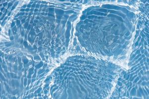 Blue water with ripples on the surface. Defocus blurred transparent blue colored clear calm water surface texture with splashes and bubbles. Water waves with shining pattern texture background texture photo