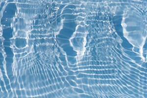 Blue water with ripples on the surface. Defocus blurred transparent blue colored clear calm water surface texture with splashes and bubbles. Water waves with shining pattern texture background texture photo