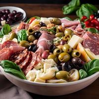 Antipasto salad with tomatoes, olives, salami, tomatoes, cheese, artichokes and basil. photo