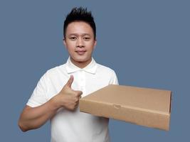 Man holding cardboard box with thumbs up gesture photo