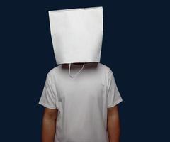 Man posing covering his head with a shopping bag isolated on plain background. photo