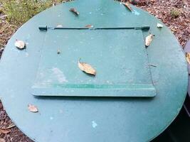 green metal garbage or trash can with closed door photo
