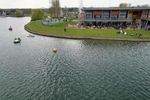 beautiful View of Willen Lake Park with Local and Tourist Public Enjoying the Beauty of Lake and Park by Walking Around with Their Families. Footage Was Captured on 09-April-2023 at Milton Keynes UK photo