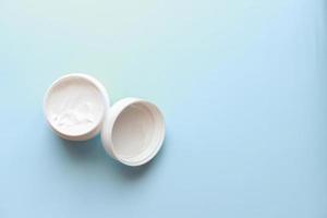Flat lay cream on blue background photo