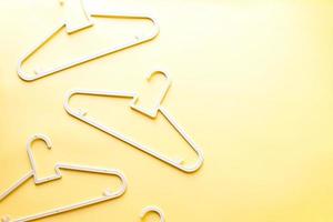 Flat lay baby hangers on yellow background photo