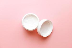 Flat lay cream on pink background photo