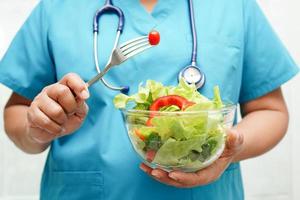 Asian Nutritionist holding healthy food for patient in hospital, nutrition and vitamin. photo