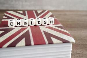 Inglés libro con graduado sombrero, aprendizaje y tutorial para extranjero. foto