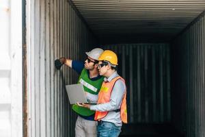 Team Engineer and worker wear safety uniform check control loading freight cargo container use computer laptop at commercial dock warehouse,transportation import,export logistic industrial service photo