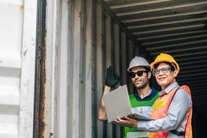 Team Engineer and worker wear safety uniform check control loading freight cargo container use computer laptop at commercial dock warehouse,transportation import,export logistic industrial service photo