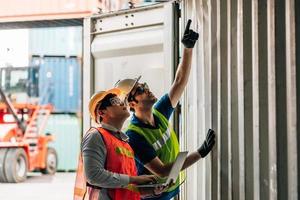 Team Engineer and worker wear safety uniform check control loading freight cargo container use computer laptop at commercial dock warehouse,transportation import,export logistic industrial service photo