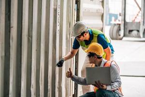 Team Engineer and worker wear safety uniform check control loading freight cargo container use computer laptop at commercial dock warehouse,transportation import,export logistic industrial service photo
