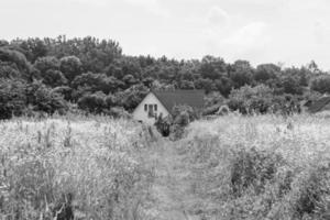 hermosa y antigua casa de campo abandonada en el campo sobre fondo natural foto