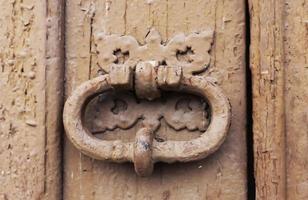 Iron door knocker on a wooden door photo
