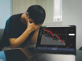 man who is stressed out stock market trend down and broker despair on charts and numbers with bear time investment loss photo