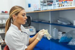 Portrait of female scientist in laboratory. Confident scientist wearing lab coat standing photo
