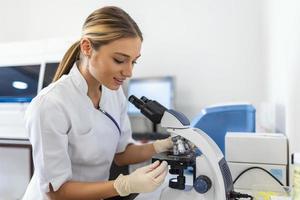 Scientist biochemist or microbiologist working research with a microscope in laboratory. photo