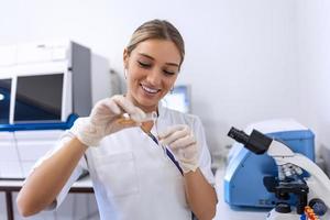 Researcher, doctor, scientist or laboratory assistant working with plastic medical tubes in modern lab or hospital photo