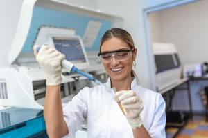 retrato de hembra científico con un pipeta análisis un líquido a extraer el adn y moléculas en el prueba tubos en laboratorio. concepto de investigación, bioquímica, farmacéutico medicina foto