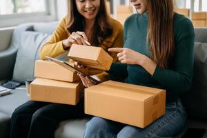 young Asian woman and woman at office of their business online shopping.In home office photo