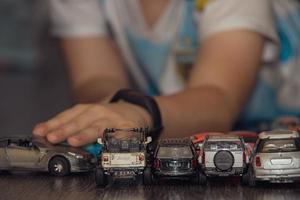 colorful toy cars arranged in a row on the floor during a child's play photo