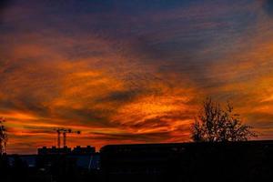 natural dramatic with clouds colorful urban sunset with construction crane photo