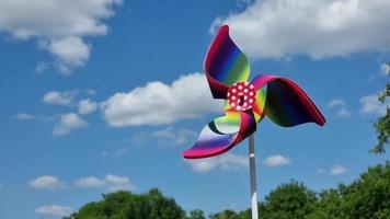 Colorful pinwheel on a background of blue sky with white clouds video