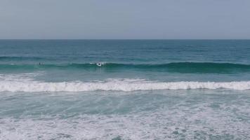 surfeurs à le plage de raso pendant été dans carballo, la corogne, galice, Espagne. large, lent mouvement video