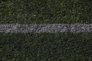 green background of artificial turf football field in closeup photo