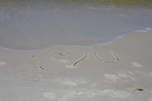 inscription on the sand on the sea shore I love you photo