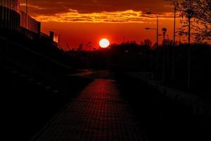 red sunset in the city with a road and walking couple of people in love photo