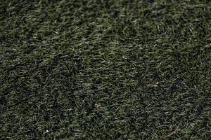 green background of artificial turf football field in closeup photo