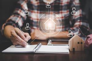Engineering and architecture drawings and mini home model concept, Engineer man writing of architect starting draw a house blueprint on the desk in the home office, work from home, Real estate offer photo