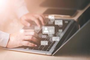 Businessman working with laptop, Social media and Marketing virtual icons screen concept, businessman typing keyboard with laptop computer on wooden desk in modern office,online communication contact. photo