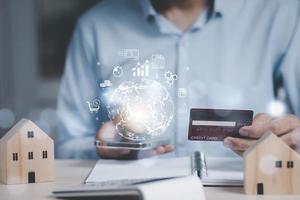 Businessman holding credit card and arrow icon market graph on Internet on the laptop computer with credit card, online payment, shopping online, e-commerce, internet banking, spending money concept. photo