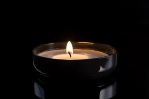 un vela es iluminado en el oscuro transporte monumento muerte y esperanza. ai generado foto