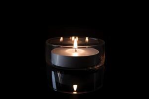 un vela es iluminado en el oscuro transporte monumento muerte y esperanza. ai generado foto