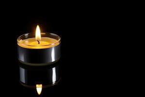 un vela es iluminado en el oscuro transporte monumento muerte y esperanza con Copiar espacio. ai generado foto
