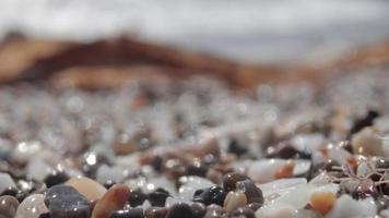 cerca arriba macro vídeo de piedras y guijarros consiguiendo cubierto como el marea viene en video