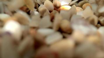 Close up macro video of stones and pebbles getting covered as the tide comes in