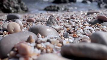 Close up macro video of stones and pebbles getting covered as the tide comes in