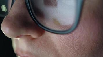 Woman in glasses looking on the monitor and surfing Internet. The monitor screen is reflected in the glasses video