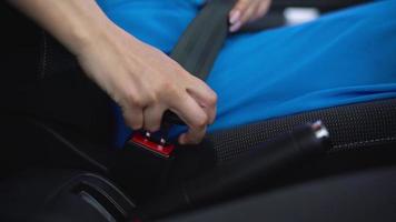 mujer desabrochando coche la seguridad asiento cinturón mientras sentado dentro de vehículo después conducción video