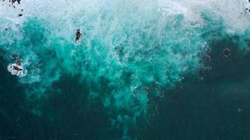 topp se av en folktom svart vulkanisk strand. kust av de ö av teneriffa. antenn Drönare antal fot av hav vågor nå Strand video